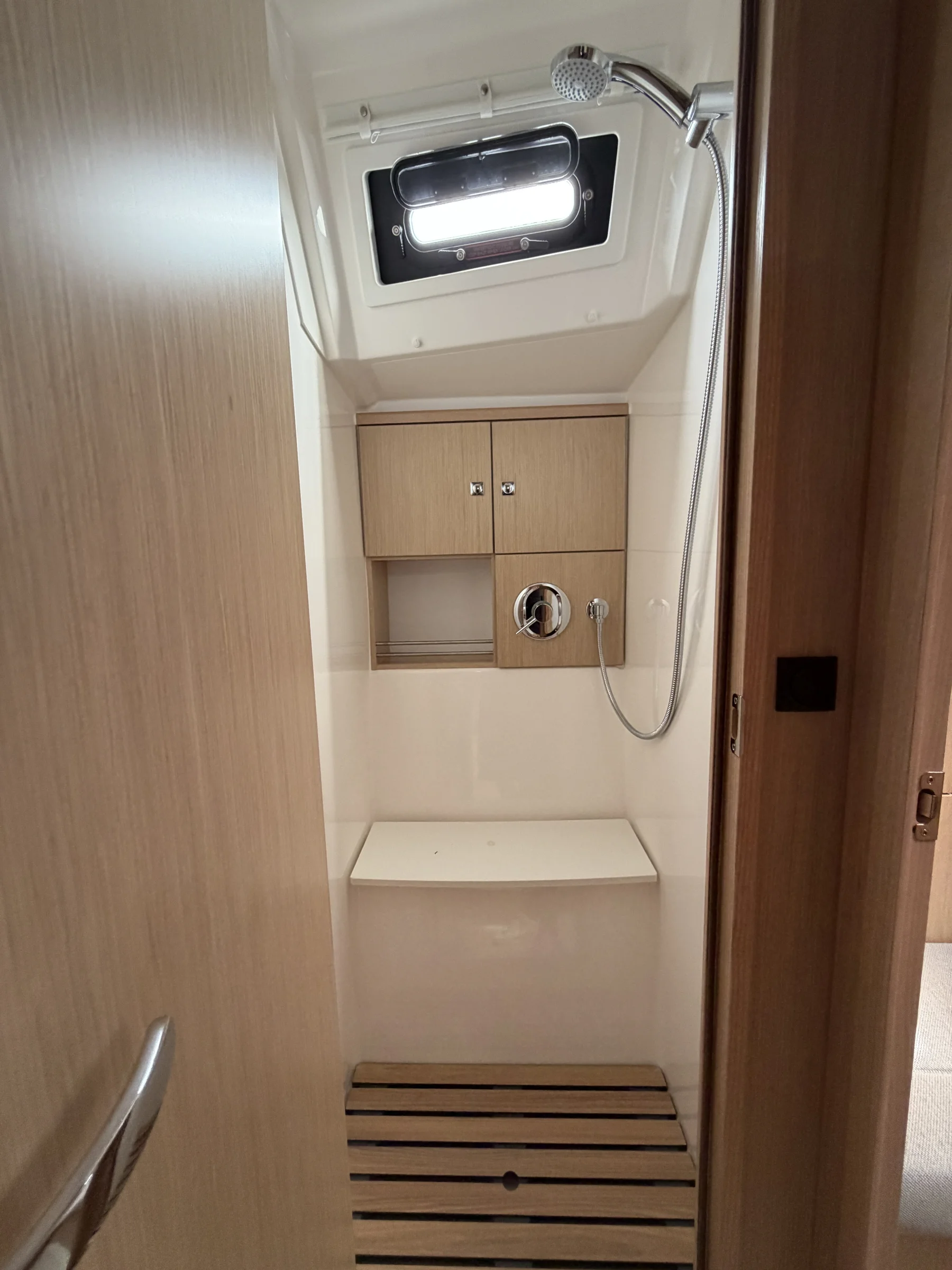 Dusche mit Handbrause und Teak-Duschmatte